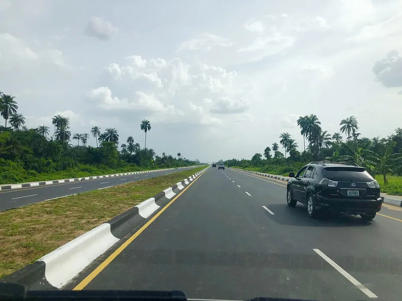 A dual carriageway bypass road lined with palm trees in Yenagoa, the Bayelsa State capital