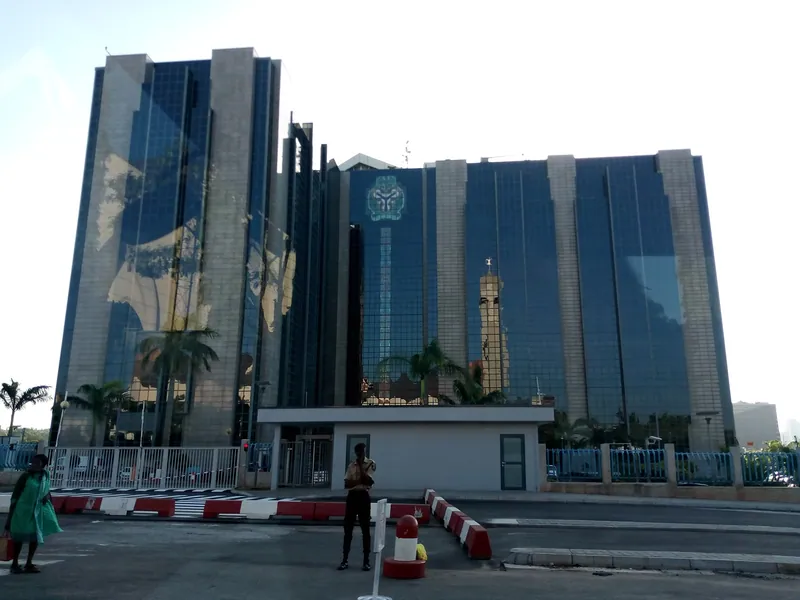 Central Bank of Nigeria building in Abuja, with a guard standing at the gate