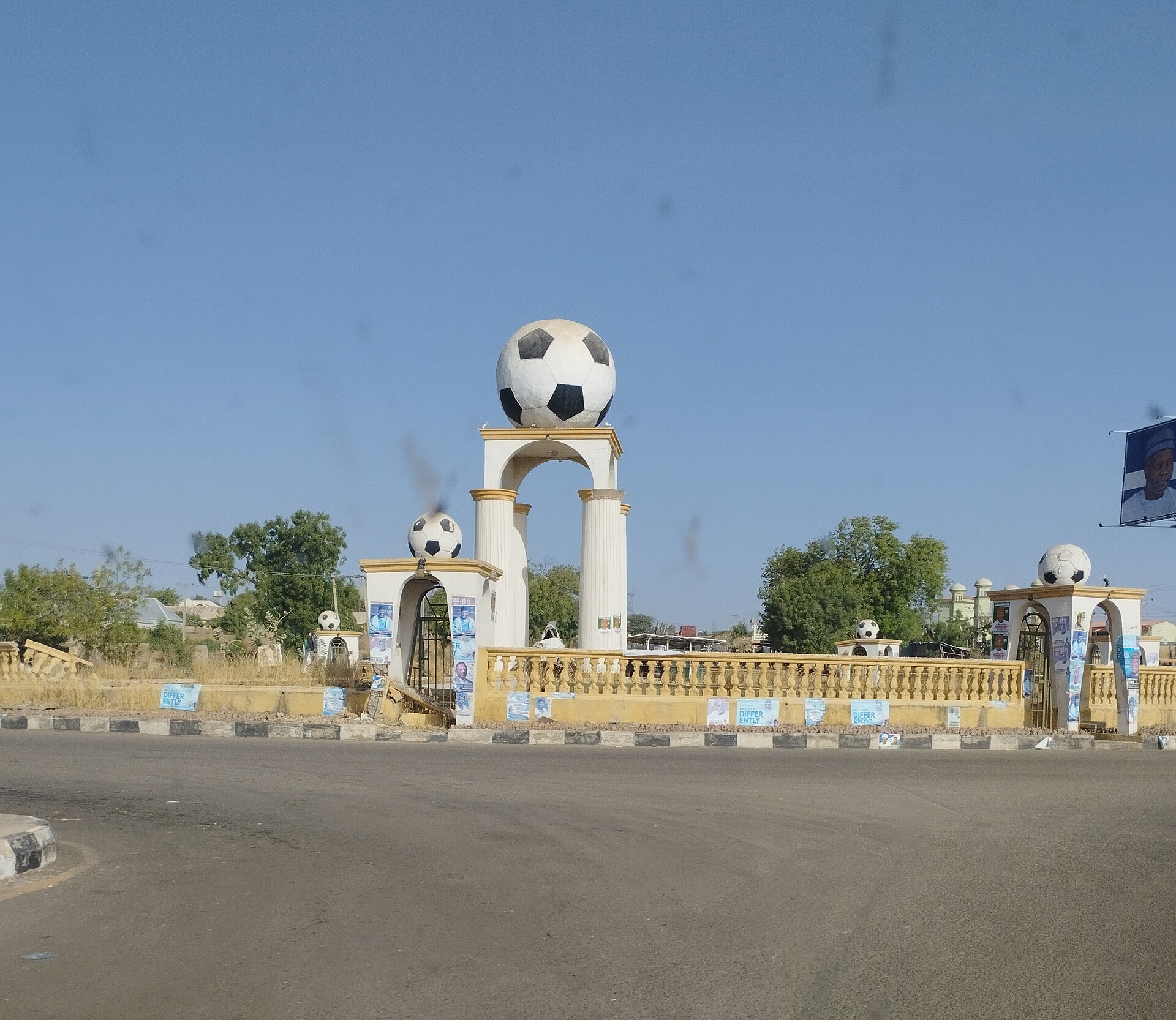 Football monument roundabout in Gombe city in March 2022, with campaign posters from that period on its railings